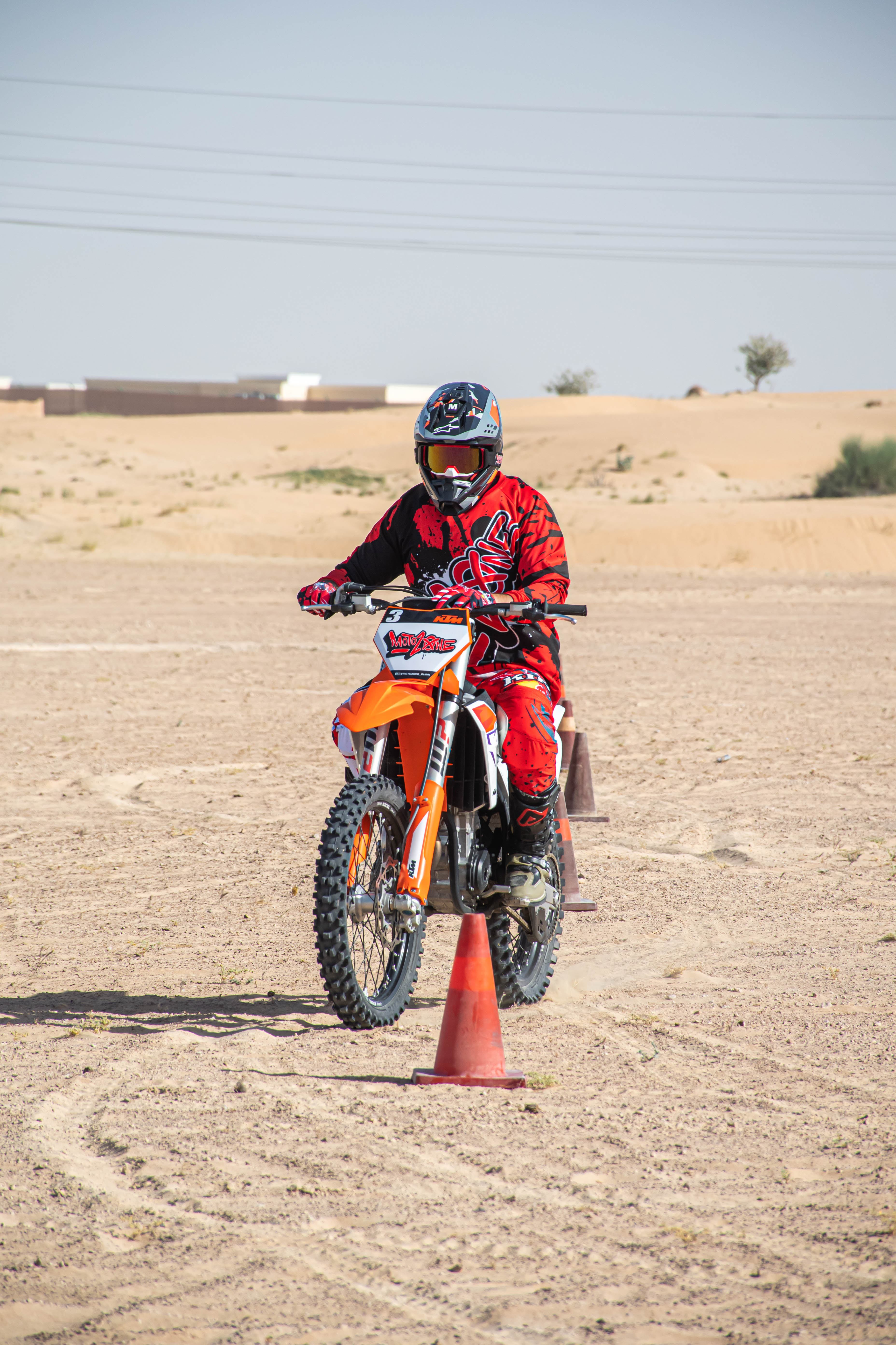 KTM dirt bike rider practicing motocross training on desert sand cones in Dubai