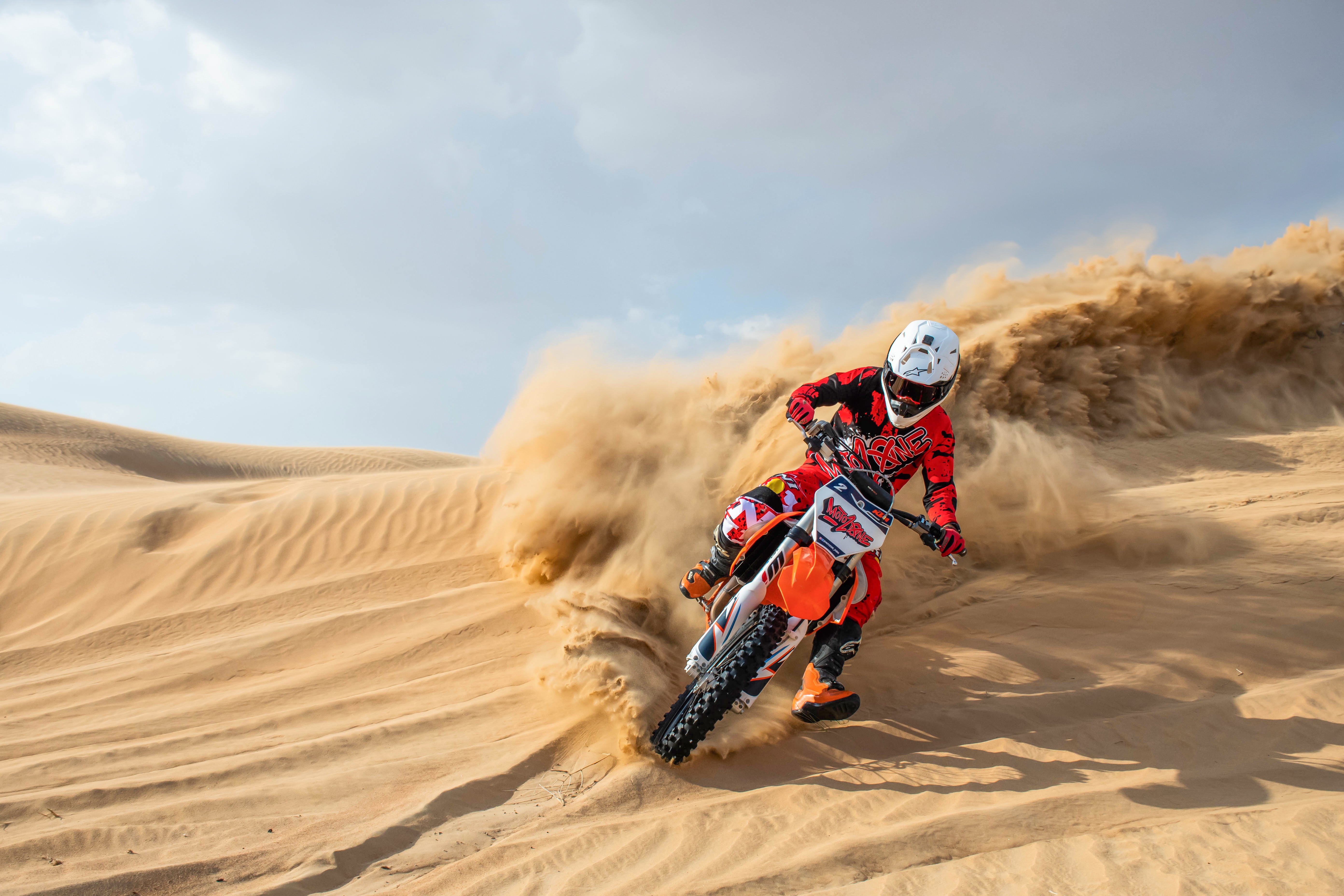 Two happy motocross riders on a KTM dirt bike during a guided desert riding experience in Dubai