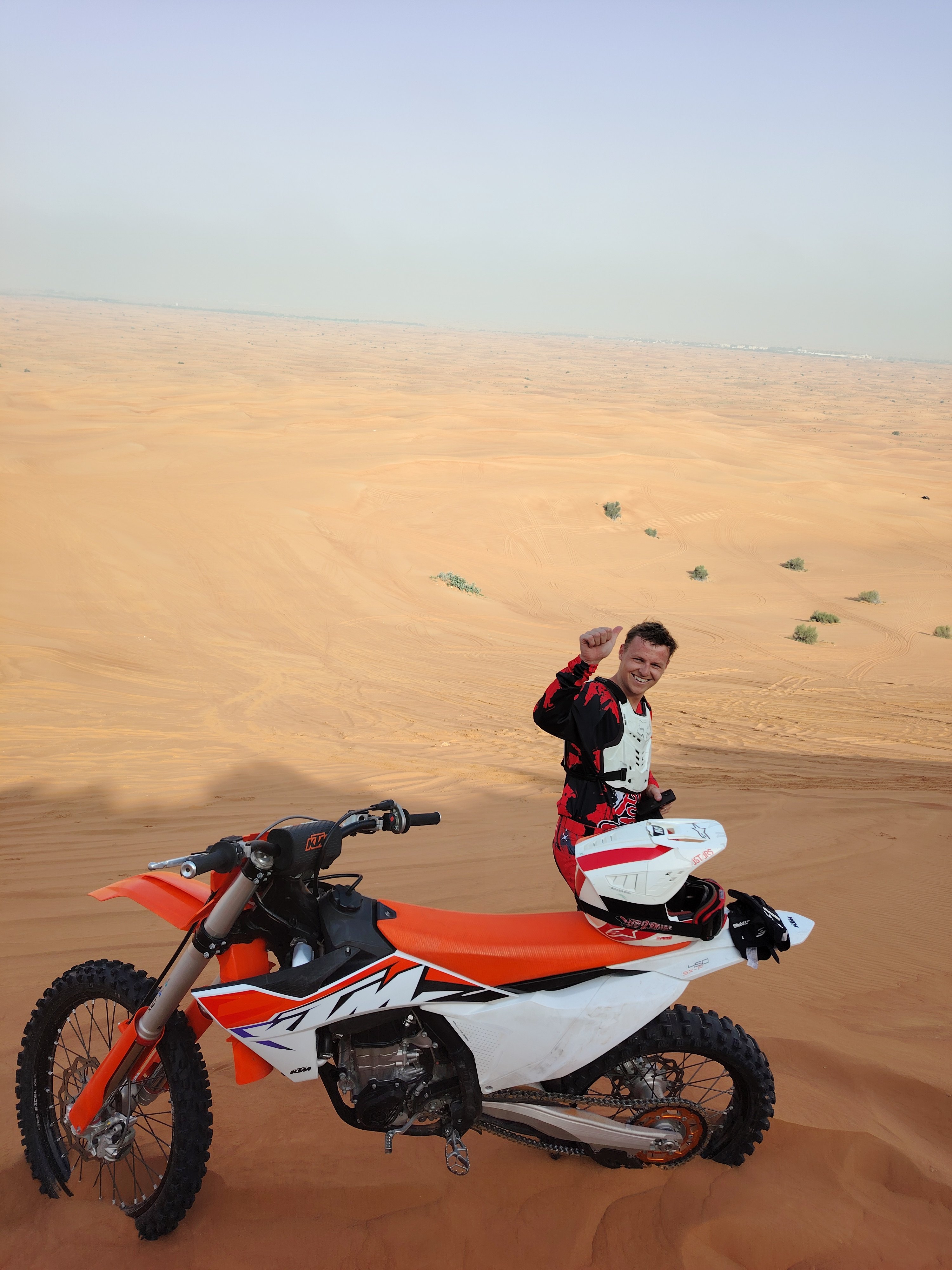 Motocross rider performing a high-speed sand turn during a Dubai desert dirt bike adventure tour