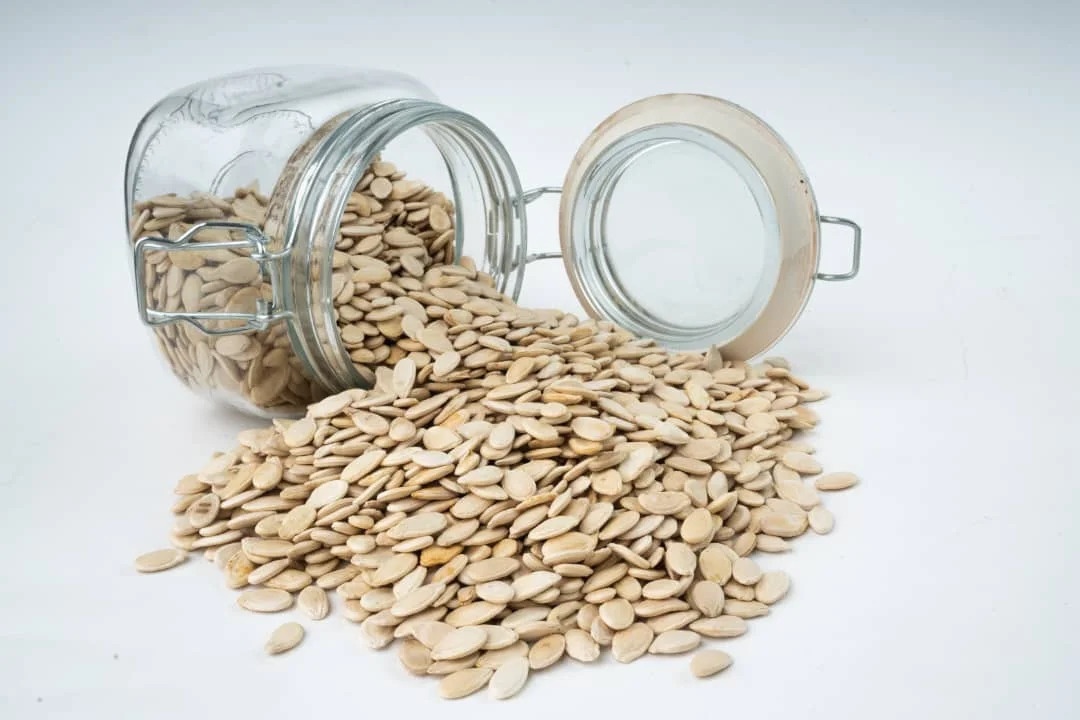 Sesame seeds in a clay bowl and spread out – natural oilseed for culinary and industrial use.