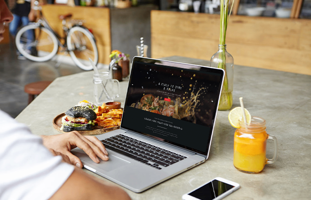 Responsive restaurant website design displayed on laptop for Golden Fork hospitality brand portfolio by Prism Digital.